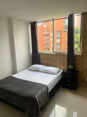 a bed in a room with a window at Lindo apartamento poblado 111 in Medellín