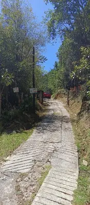 a stone road with a red car on the side at Sanayá Domo Glamping - Santa Elena in Santa Elena