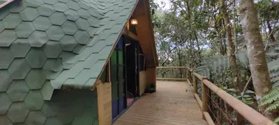 a wooden walkway leading to a house with a green roof at Sanayá Domo Glamping - Santa Elena in Santa Elena