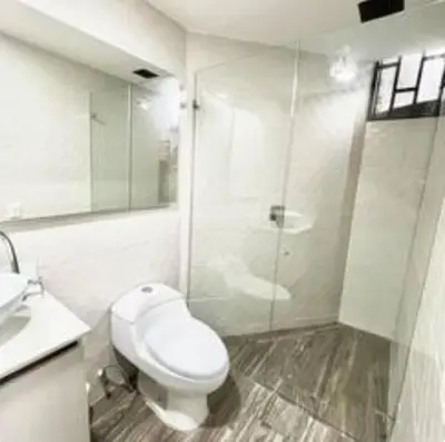 a white bathroom with a toilet and a shower at Apartamento Laureles con Jacuzzi cerca al primer parque in Medellín