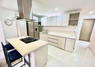 a kitchen with white cabinets and a stove top oven at Apartamento Laureles con Jacuzzi cerca al primer parque in Medellín
