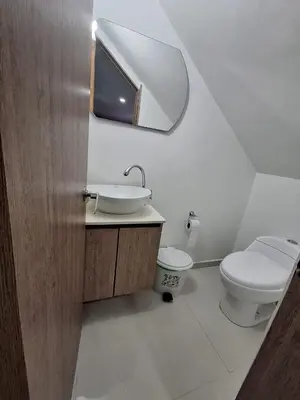 a bathroom with a toilet and a sink and a mirror at Apartamento Laureles con Jacuzzi cerca al primer parque in Medellín