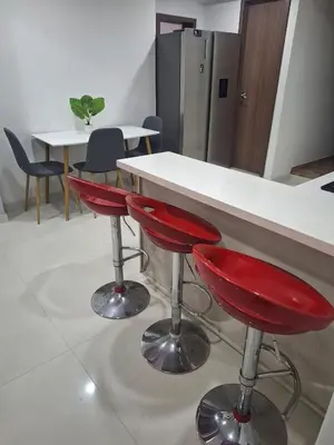 a kitchen with two red bar stools at a counter at Apartamento Cerca a Primer Parque de Laureles in Medellín