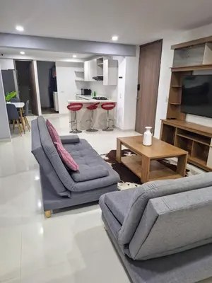 a living room with two couches and a table at Apartamento Cerca a Primer Parque de Laureles in Medellín