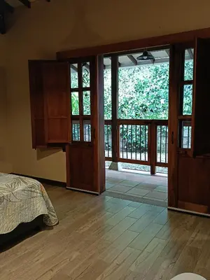 a bedroom with a bed and a sliding glass door at Finca MonteSer in Jardin