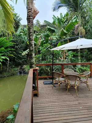 a wooden deck with a table and chairs and an umbrella at Finca MonteSer in Jardin