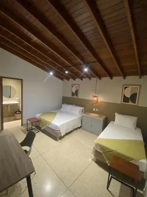 a bedroom with two beds and a wooden ceiling at Hotel La Vega in Concepción