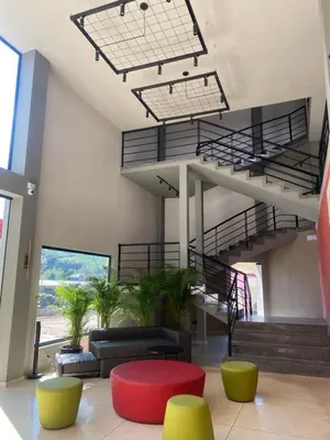 a lobby with stairs and a couch and a table at Hotel La Vega in Concepción