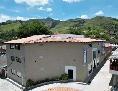 a building with a mountain in the background at Hotel La Vega in Concepción