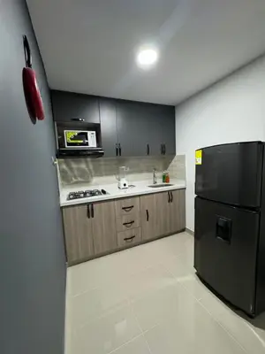 a kitchen with a black refrigerator and a sink at Apartamento céntrico en Medellín in Medellín