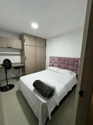 a bedroom with a large bed with a pink headboard at Apartamento céntrico en Medellín in Medellín