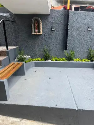 a bench sitting next to a wall with a statue at Apartamento céntrico en Medellín in Medellín