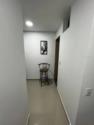 a hallway with a table and a chair in a room at Apartamento cerca al centro en Medellín in Medellín