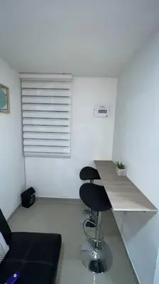 a room with a counter with two stools and a table at Apartamento cerca al centro en Medellín in Medellín