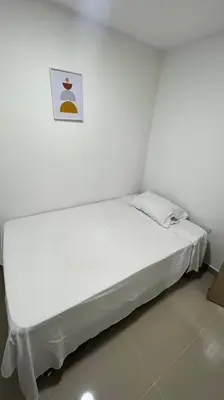 a white bed in a room with a picture on the wall at Apartamento cerca al centro en Medellín in Medellín