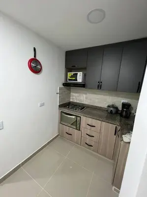a small kitchen with a stove and a microwave at Apartamento cerca al centro en Medellín in Medellín