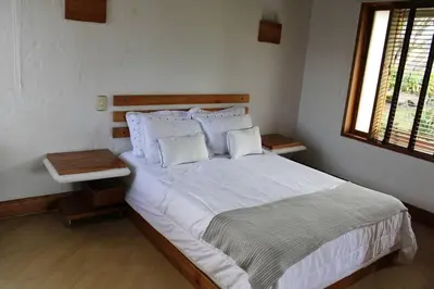 a bedroom with a large bed with white sheets and pillows at Casa finca pietrasanta in Rionegro