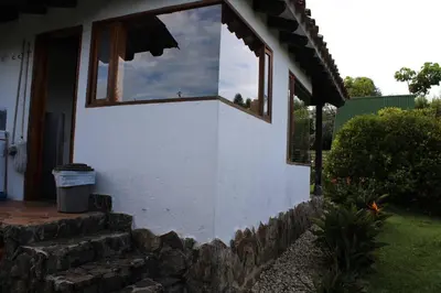 a white house with a window on the side of it at Casa finca pietrasanta in Rionegro