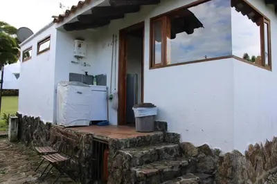 a small white house with a porch with a refrigerator at Casa finca pietrasanta in Rionegro