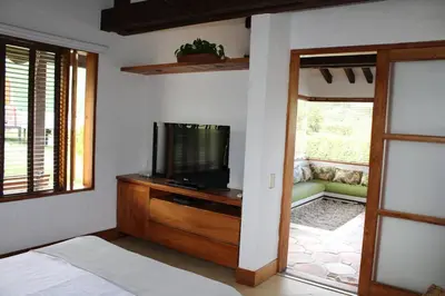 a bedroom with a tv on a dresser with a bed at Casa finca pietrasanta in Rionegro