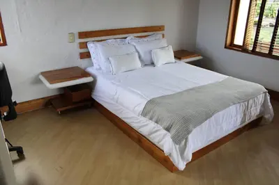 a bedroom with a large bed with white sheets and pillows at Casa finca pietrasanta in Rionegro