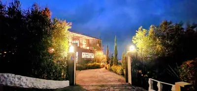 a house at night with lights on a driveway at Hobbit Hotel El peñol Guatapé in La Pradera
