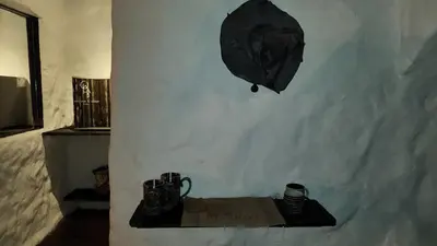 a room with a table and a box on a wall at Hobbit Hotel El peñol Guatapé in La Pradera