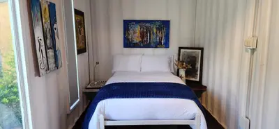a bedroom with a bed in a room with a window at Hobbit Hotel El peñol Guatapé in La Pradera