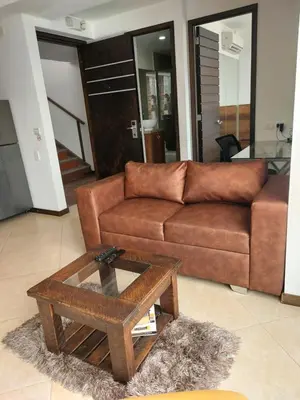 a living room with a brown couch and a coffee table at Laureles Penthouse rooftop Suite in Medellín