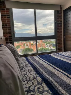 a bedroom with a large window with a view of a city at Laureles Penthouse rooftop Suite in Medellín