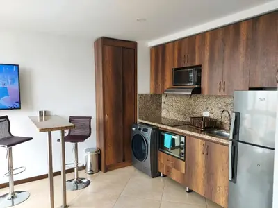 a kitchen with a refrigerator and a table with chairs at Laureles Penthouse rooftop Suite in Medellín