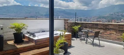 a bath tub on a balcony with a table and chairs at Laureles Penthouse rooftop Suite in Medellín