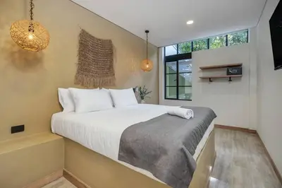 a bedroom with a large bed with white sheets at MULATA - Provenza 3 Story Villa with Pool & Rooftop in Medellín