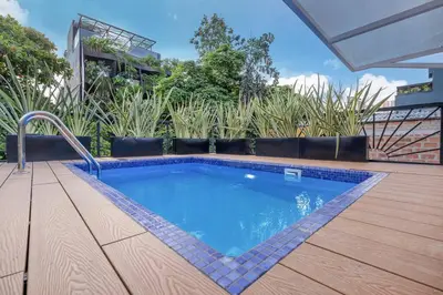 a small swimming pool on a wooden deck at MULATA - Provenza 3 Story Villa with Pool & Rooftop in Medellín