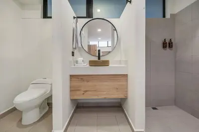 a bathroom with a sink and a toilet and a mirror at MULATA - Provenza 3 Story Villa with Pool & Rooftop in Medellín
