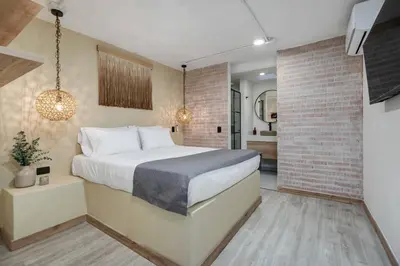 a bedroom with a bed and a brick wall at MULATA - Provenza 3 Story Villa with Pool & Rooftop in Medellín