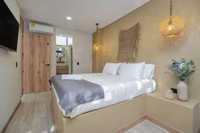a bedroom with a large bed with white sheets at MULATA - Provenza 3 Story Villa with Pool & Rooftop in Medellín