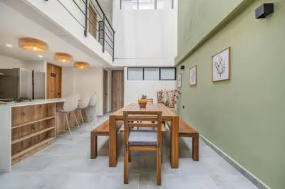 a kitchen and dining room with a wooden table and chairs at MULATA - Provenza 3 Story Villa with Pool & Rooftop in Medellín