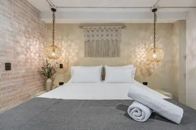 a bedroom with a large white bed with two lights at MULATA - Provenza 3 Story Villa with Pool & Rooftop in Medellín