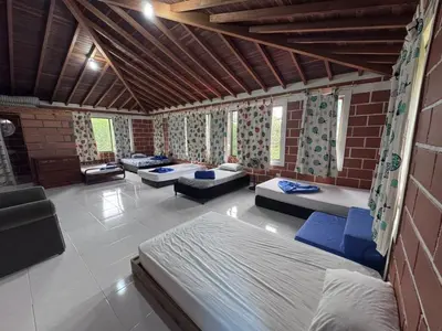 a room with several beds and chairs in it at Finca Kikua in San Rafael