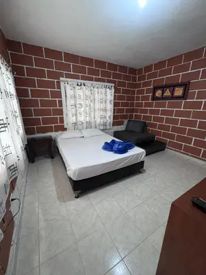 a bedroom with a bed and a brick wall at Finca Kikua in San Rafael