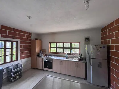 an empty kitchen with a refrigerator and a sink at Finca Kikua in San Rafael