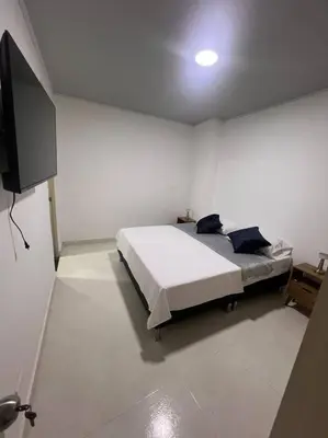 a bedroom with a bed and a flat screen tv at Hermoso Apartamento en Belén in Medellín