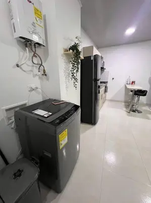 a kitchen with a black refrigerator and a table at Hermoso Apartamento en Belén in Medellín