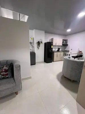 a living room with a couch and a kitchen at Hermoso Apartamento en Belén in Medellín