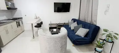 a living room with a blue couch and a tv at Hermoso Apartamento en Belén in Medellín