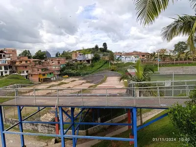 a bridge over a road in a city with houses at Apartamento en Guatapé por noches in Guatapé