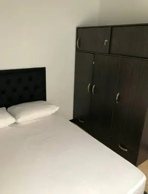 a bedroom with a bed and a black cabinet at Apartamento en Guatapé por noches in Guatapé
