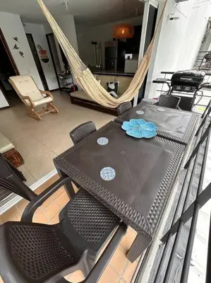 a hammock with a table and chairs on a balcony at Casa Lupita Hermoso apartasol in Santa Fe de Antioquia