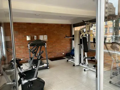 a gym with several tread machines in a brick wall at Bright and Modern Medellin Apartment in Medellín
